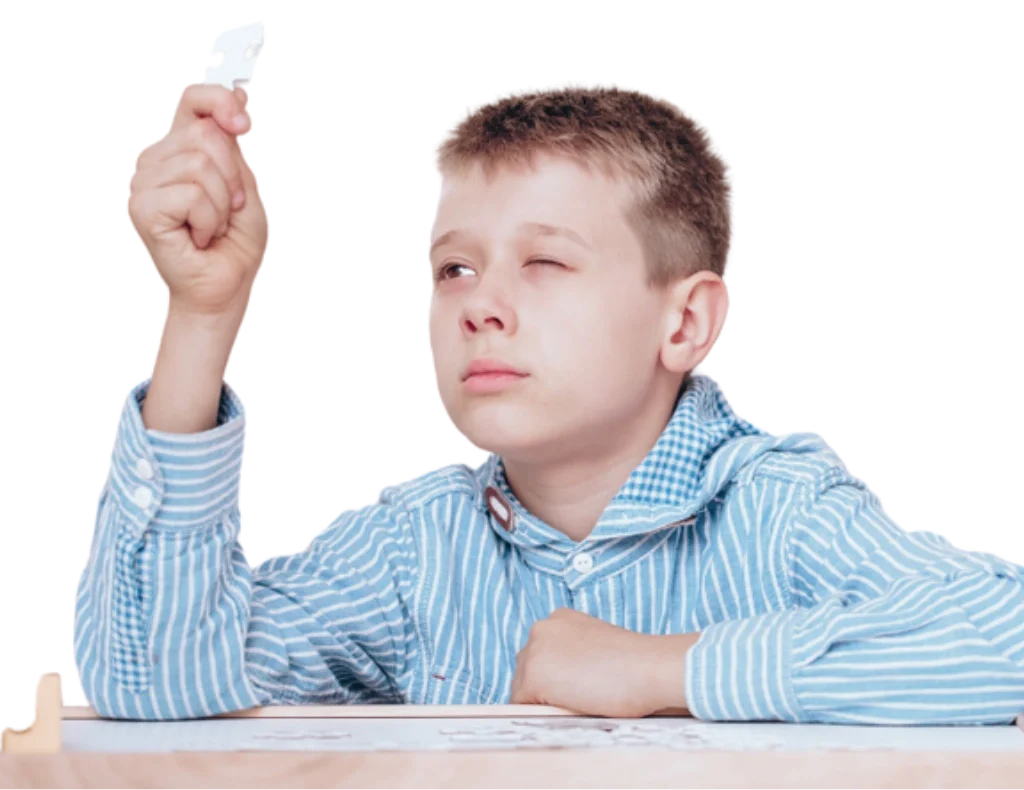 Rebellious boy doing a jigsaw puzzle during autistic kid therapy with psychotherapist